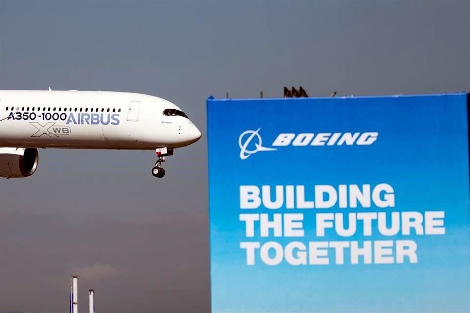 Un avión Airbus A350-1000 sobrevuela un cartel publicitario de Boeing durante un vuelo de demostración en la jornada inaugural de la 53ª edición del Salón Aeronáutico de Le Bourget este lunes.
