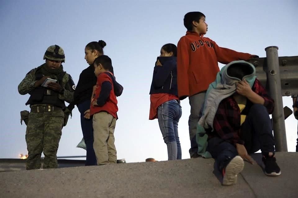 Un efectivo de la Guardia Nacional detiene a migrantes guatemaltecos en Ciudad Juárez.
