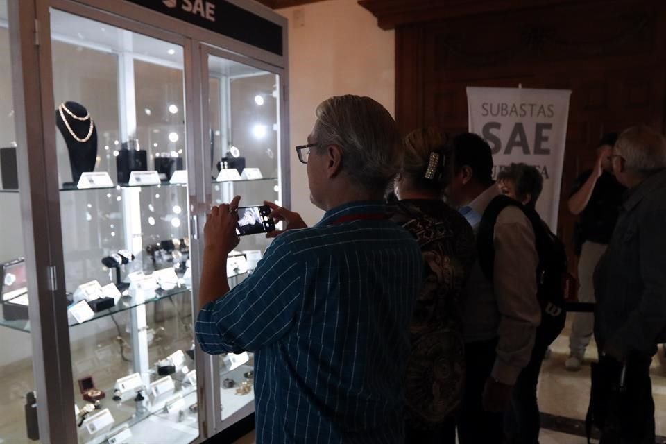 Algunos visitantes tomaron fotografías de las joyas decomisadas exhibidas en Los Pinos.
