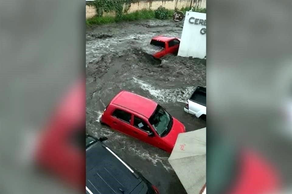 La fuerte lluvia de esta tarde inundó calles de Tlajomulco de Zúñiga, en Jalisco, donde varios automóviles quedaron atrapados.