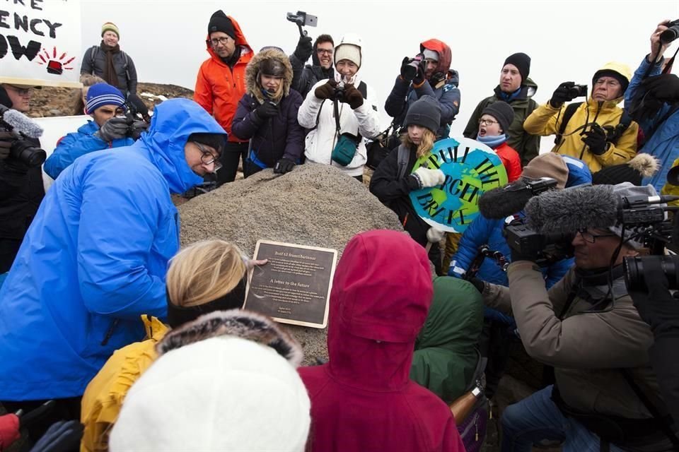 Después de que cerca de 100 personas ascendieran a un volcán durante dos horas, algunos niños colocaron una placa en conmemoración del glaciar.