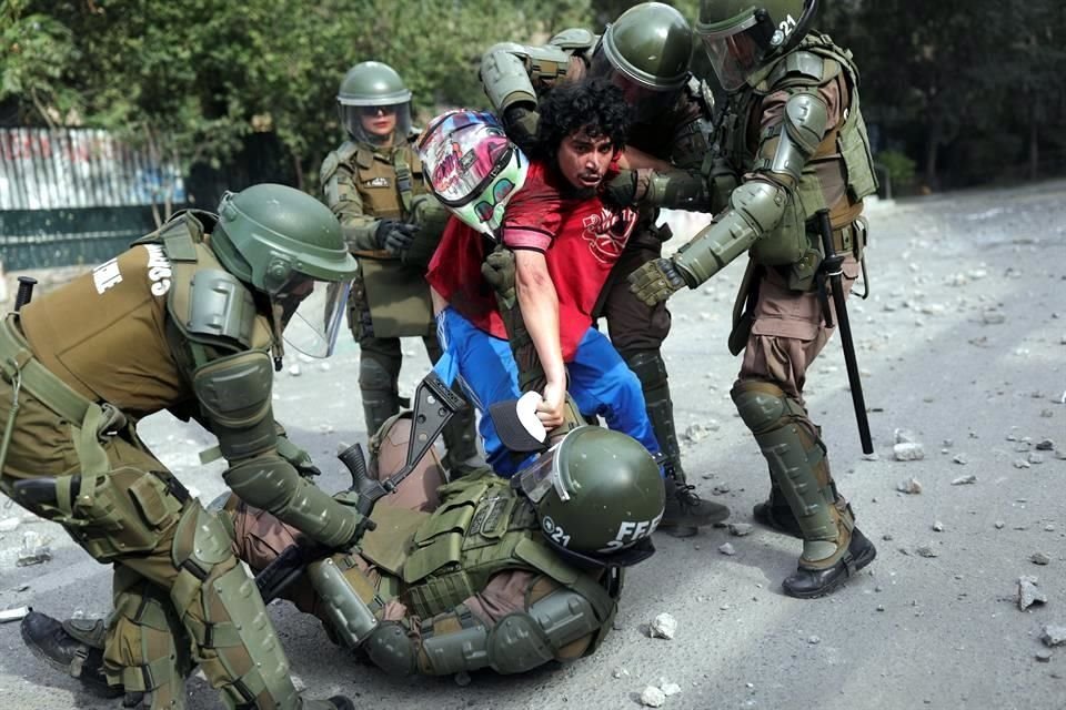 Un manifestante forcejea con Carabineros este lunes en Santiago.