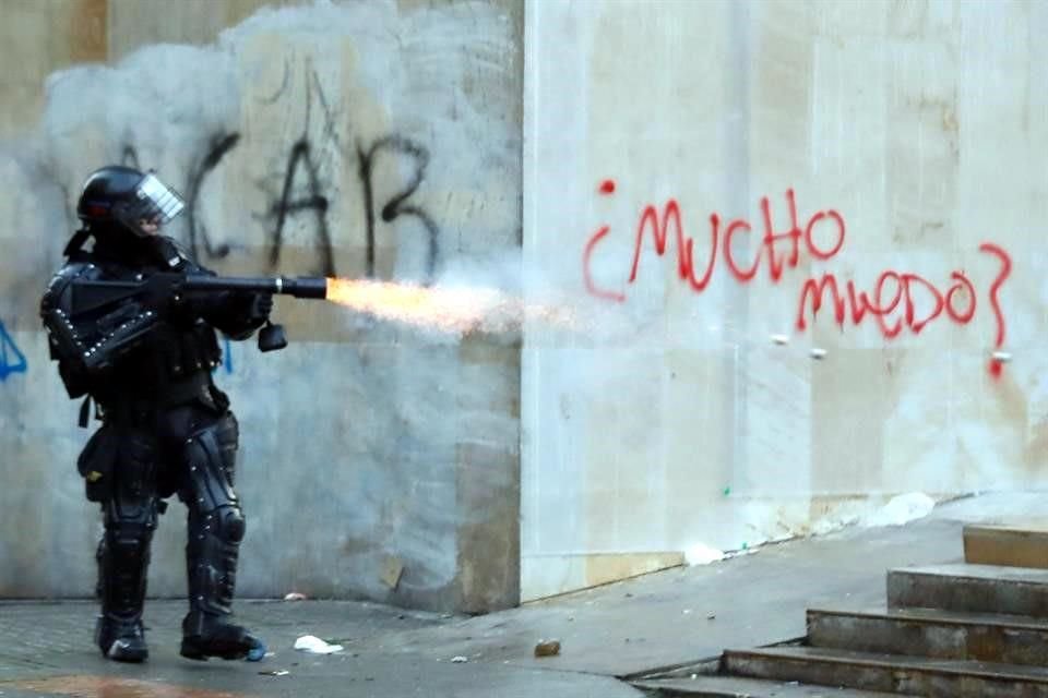 Un miembro de la Policía antidisturbios dispara durante un enfrentamiento con un grupo de manifestantes en la Plaza de Bolívar.