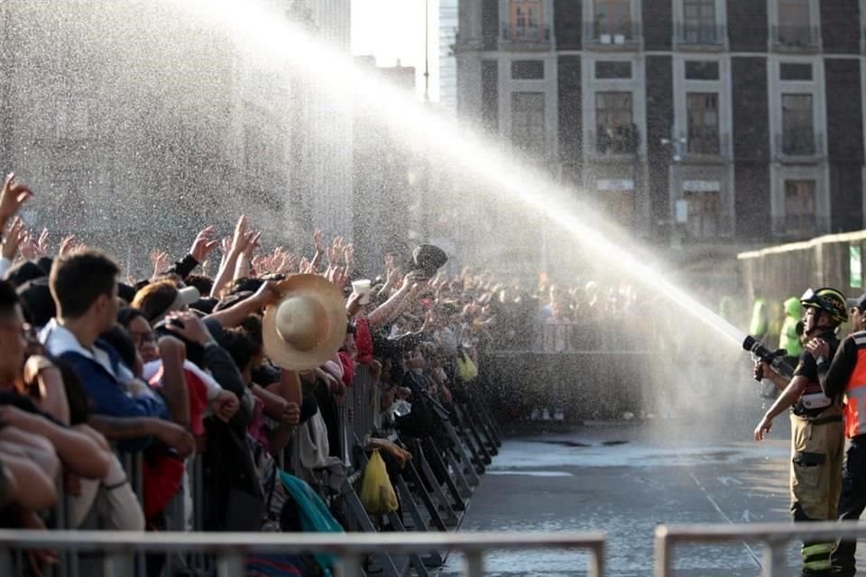 Los asistentes fueron rociados con agua con una manguera para refrescarlos del sol.