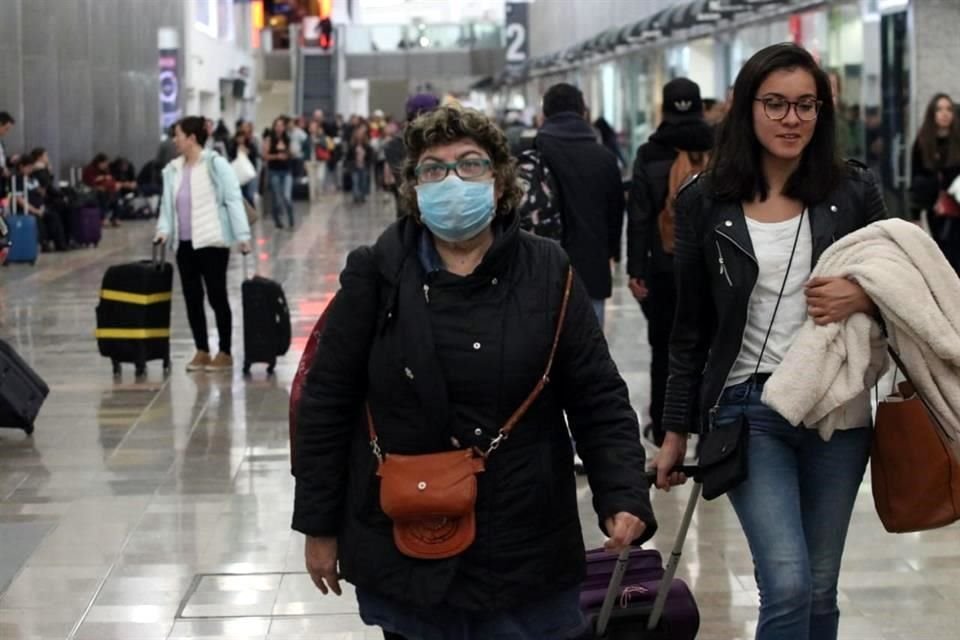 Usuarios de la Terminal aérea portan tapabocas ante el coronavirus.