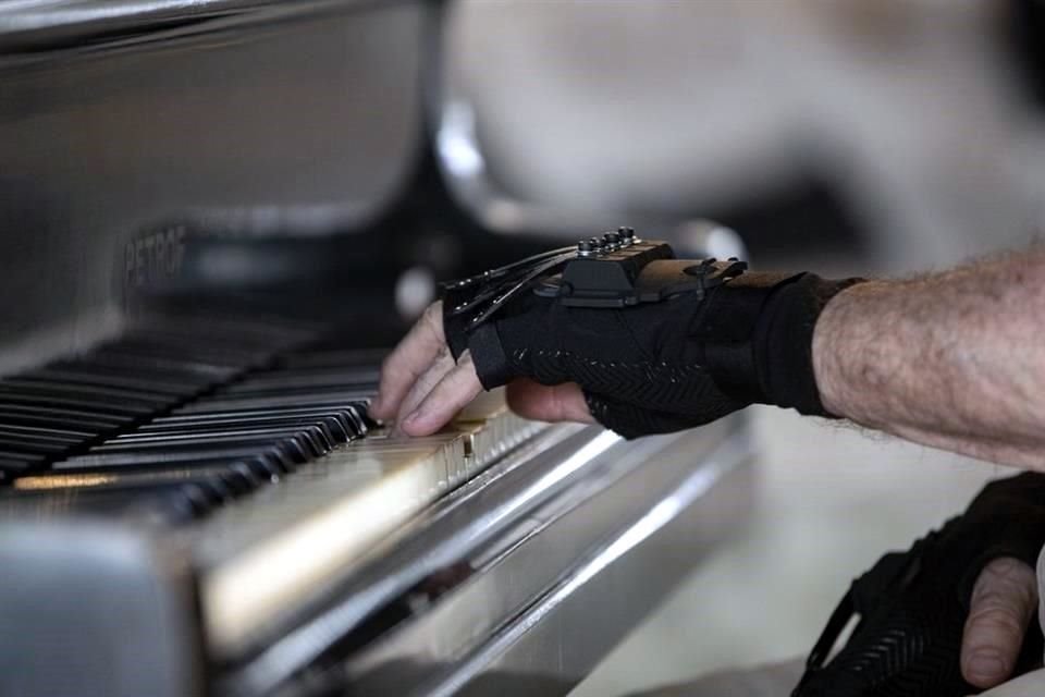 El pianista brasileño Martins toca el piano con guantes biónicos en su casa de Sao Paulo, Brasil.