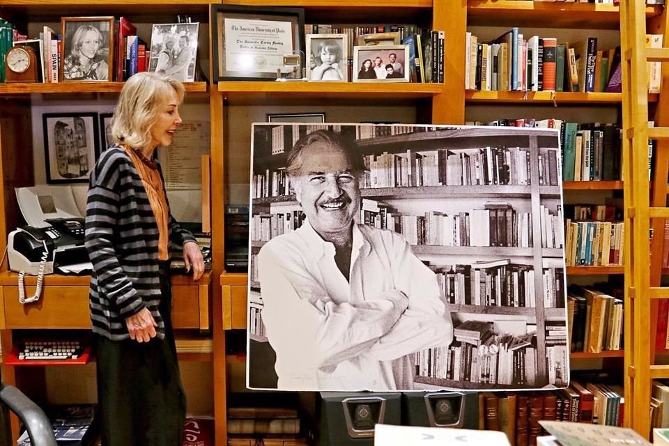 La periodista Silvia Lemus junto al retrato de Carlos Fuentes.