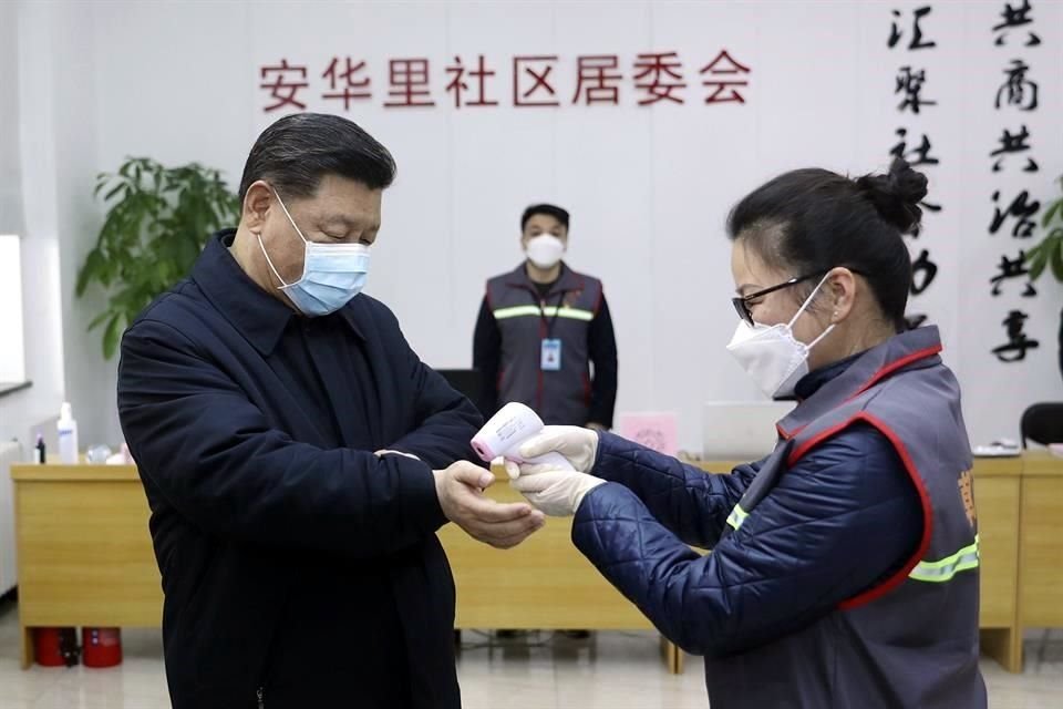 Personal toma la temperatura del Presidente chino, Xi Jinping, durante una aparición pública el 10 de febrero.