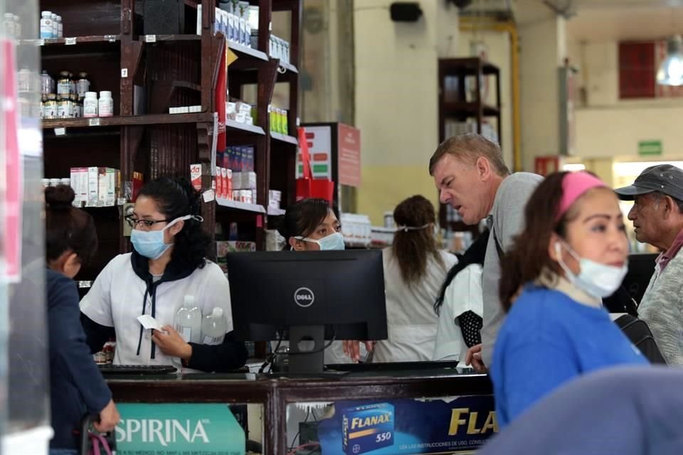 Ayer, personal y compradores con cubrebocas en una farmacia de la Ciudad de México.