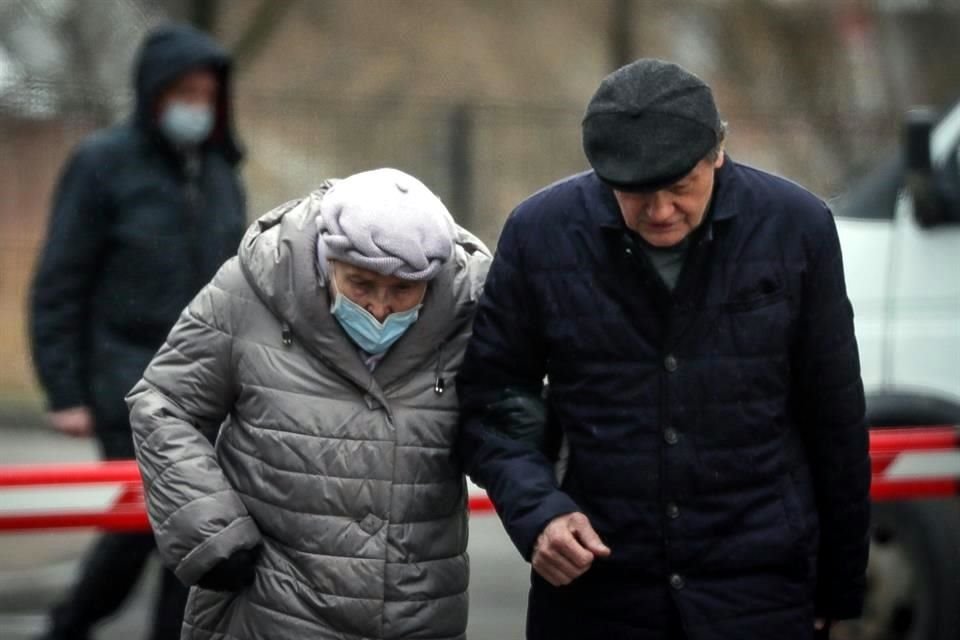 Una pareja de ancianos camina con cubrebocas en Moscú.