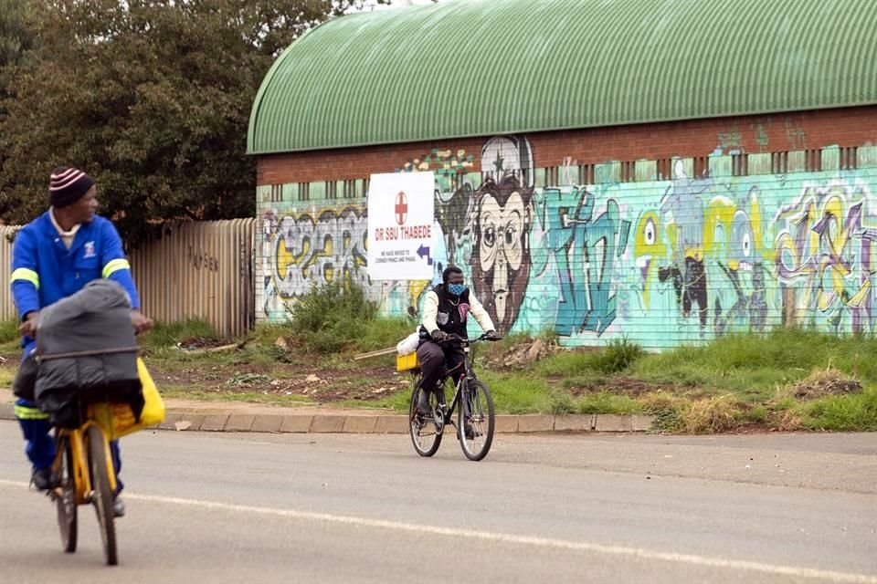 Un hombre con cubre bocas utiliza una bicicleta en Johannesburgo, Sudáfrica.