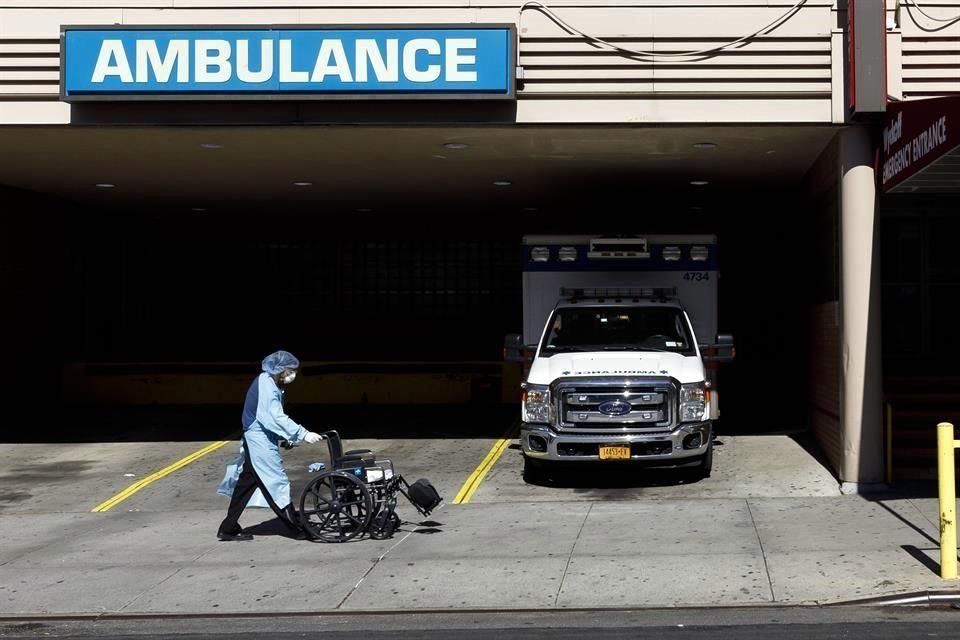 Un trabajador sanitario camina frente a la entrada de emergencias de un hospital en Nueva York.