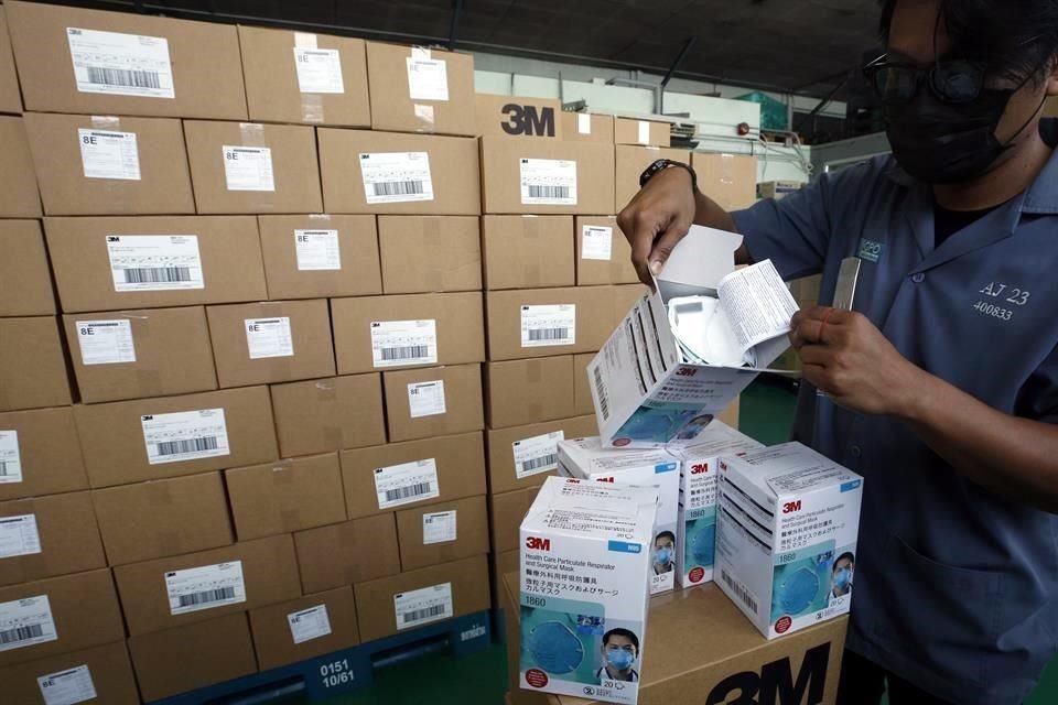 Un hombre en Tailandia revisa un paquete de mascarillas N95.