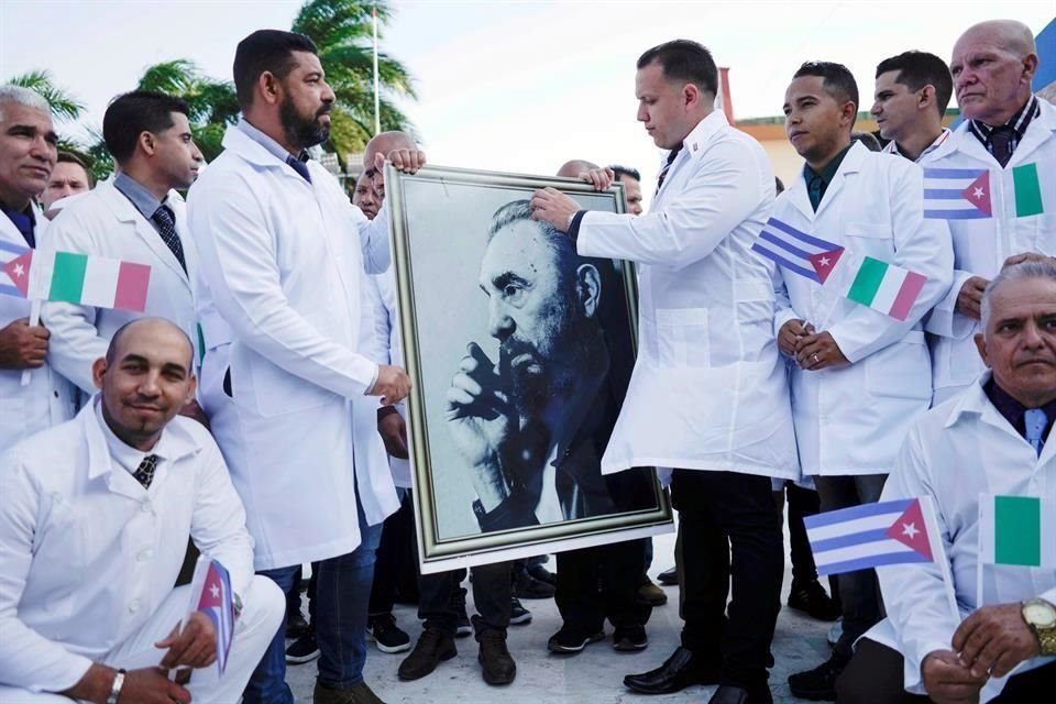 Médicos cubanos que partieron a Italia a ayudar con la pandemia de Covid-19 sostienen una foto de Fidel Castro, el pasado marzo.