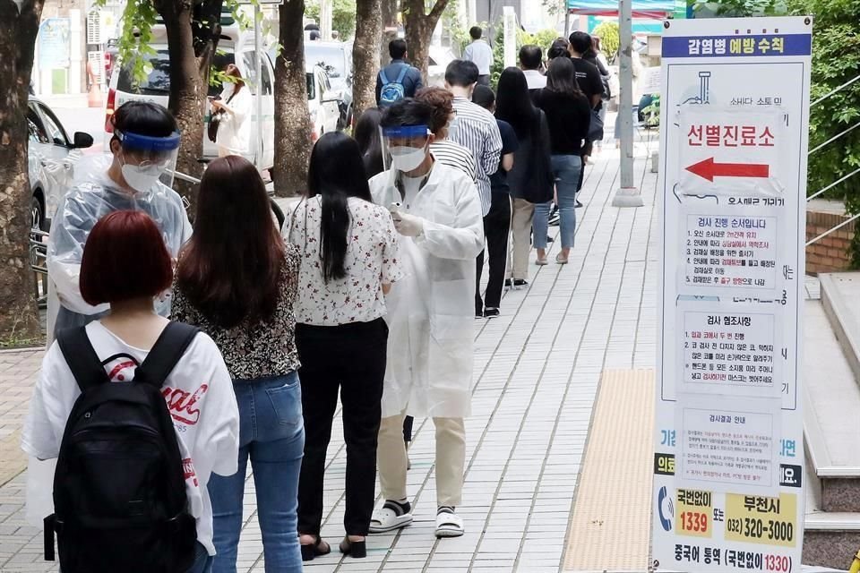 Personas esperan que se les realice prueba de Covid-19 afuera de una clínica en Bucheon, Corea del Sur.