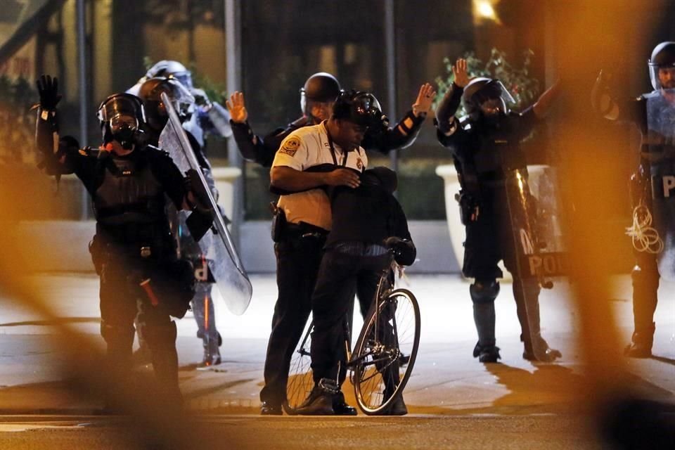 Un manifestante abrazó a un policía, mientras agentes se unieron a las protestas en Virginia.