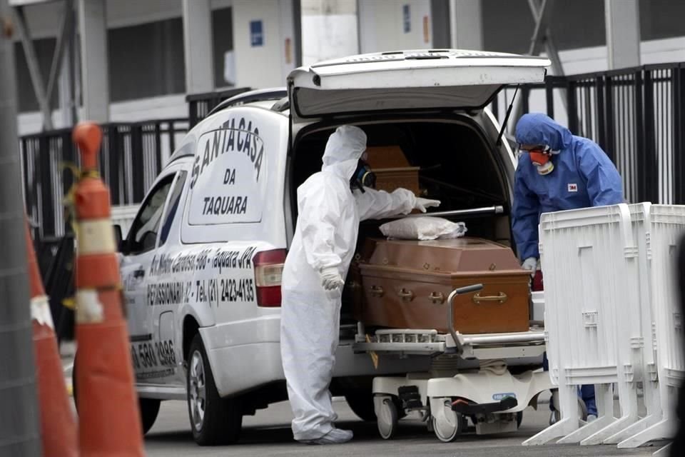 Trabajadores de una funeraria en trajes protectores trasladan los restos de una persona fallecida por Covid-19 en Río de Janeiro.