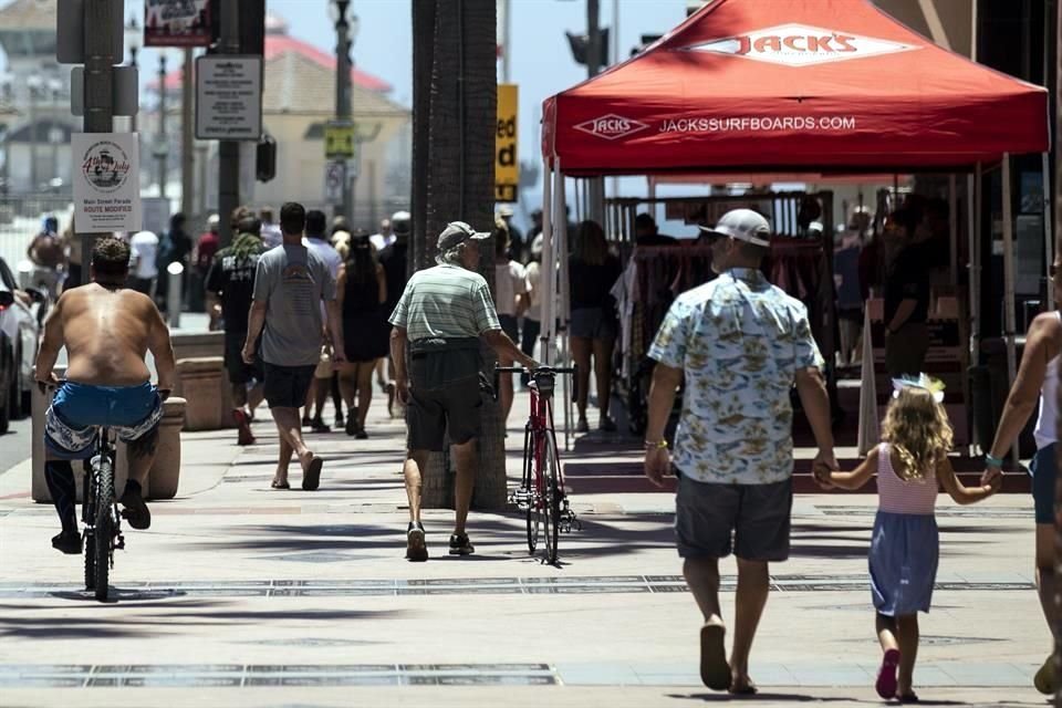 Personas caminan en las calles de Huntington Beach, California, estado que ha endurecido sus restricciones ante un aumento de casos de coronavirus.
