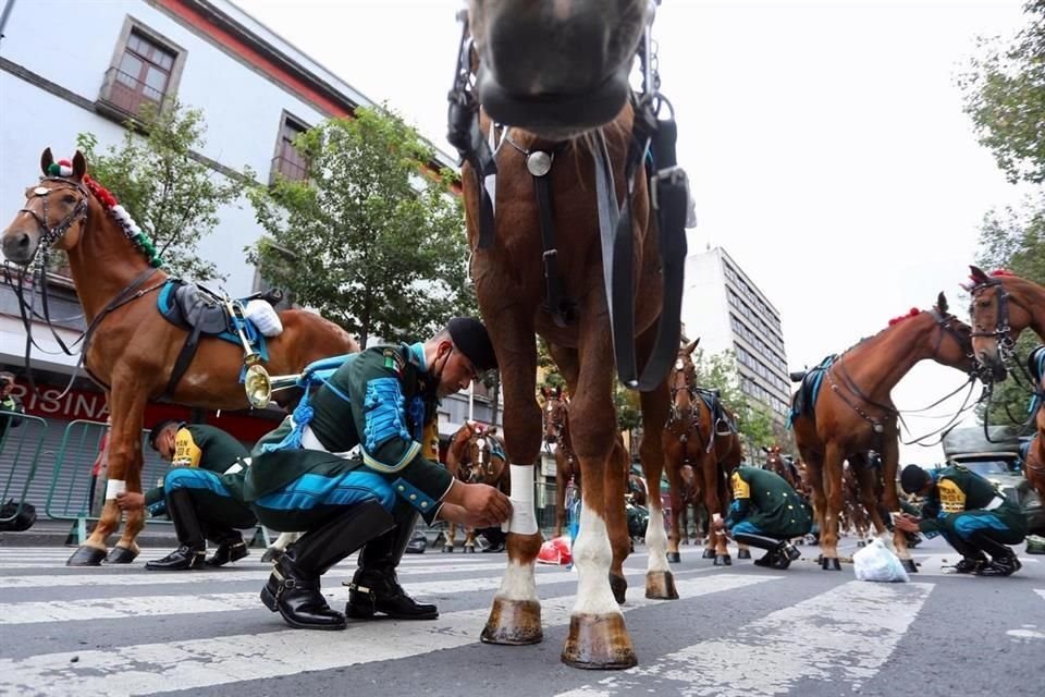 Elementos del Ejército alistan a sus caballos previo al inicio del desfile militar.
