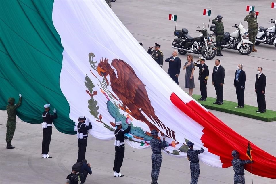 El Presidente Andrés Manuel López Obrador saluda a la bandera nacional en compañía de su esposa y Gabinete.