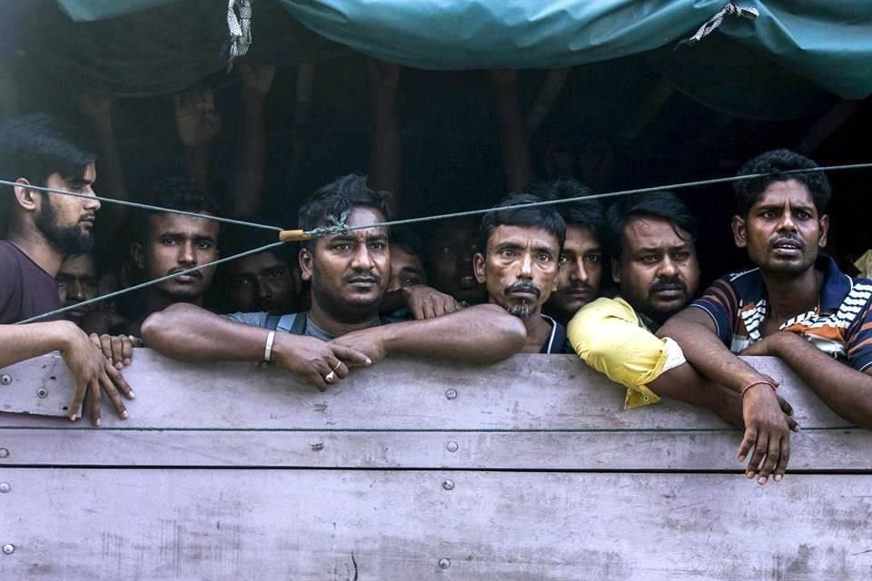 Un grupo de hombres son transportados a un centro de detención migrante en Indonesia. Fueron encontrados encerrados para ser traficados a Malasia y que trabajen en las plantaciones de palma.