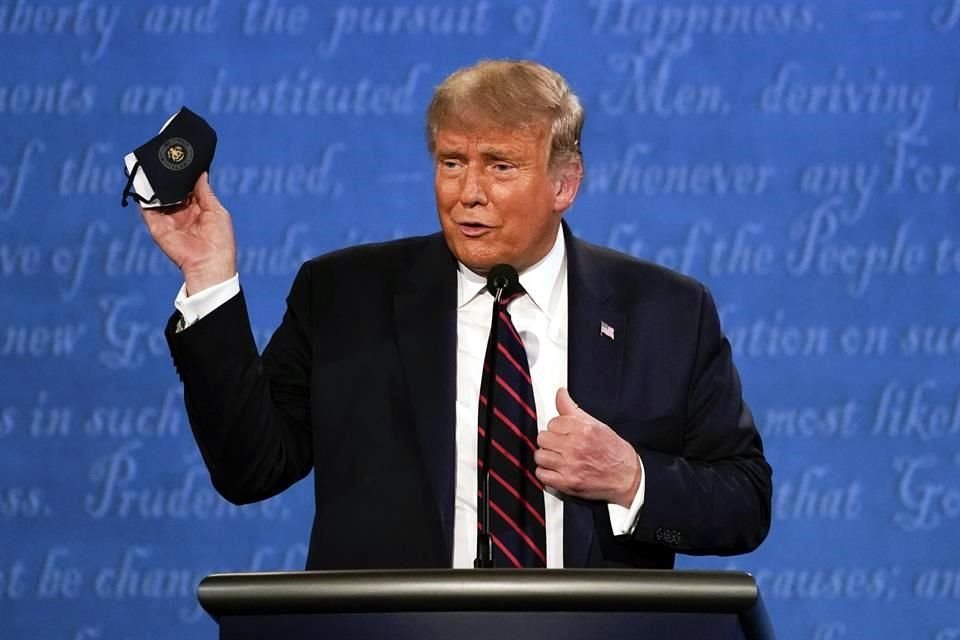 El Presidente Donald Trump muestra una mascarilla durante el debate presidencial del martes.