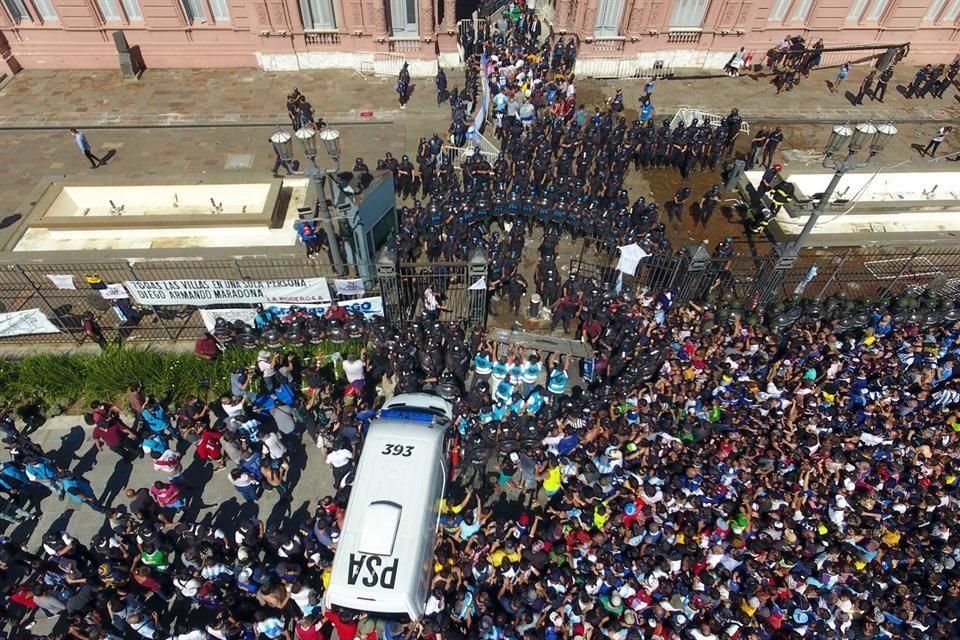 Imagen provista por la Agencia de Noticias Télam de aficionados enfrentándose con elementos de seguridad durante el funeral de Diego Armando Maradona en la Casa Rosada, en Buenos Aires.
