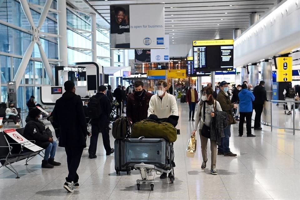 Viajeros empujan sus maletas en un aeropuerto de Inglaterra.