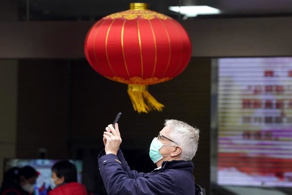Un miembro del equipo de la OMS toma fotos con su celular durante su visita a Wuhan para indagar el origen del nuevo coronavirus.