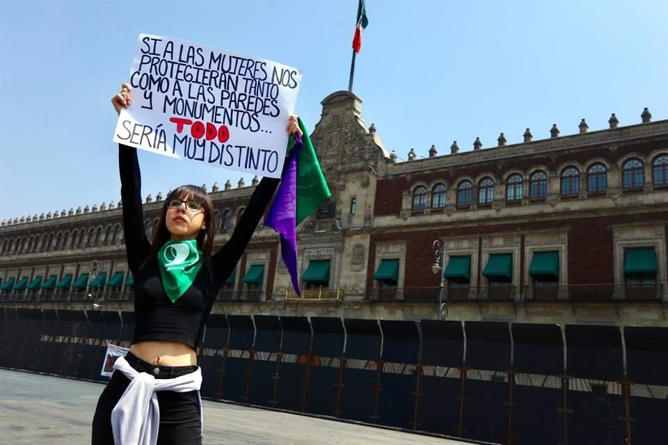 Valeria Robles, del Colectivo Nacional Feminista, acudió con un cartel a tomarse fotos en el muro de vallas metálicas.