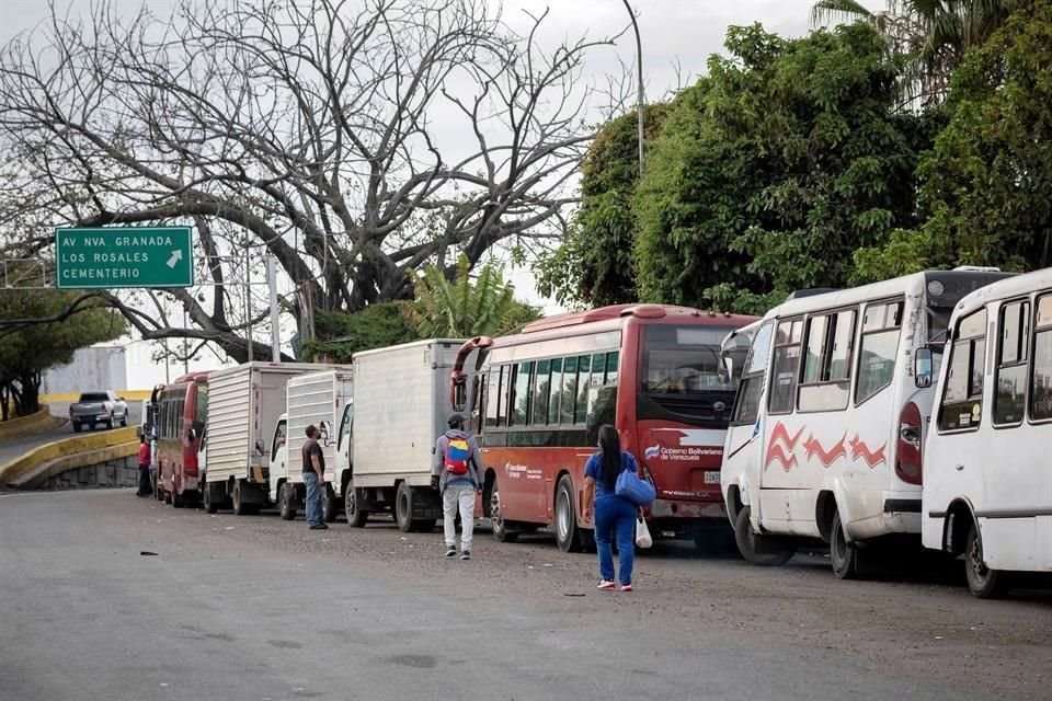 Transportistas hacen fila con sus vehículos para surtir diésel en una estación de servicio en Caracas.