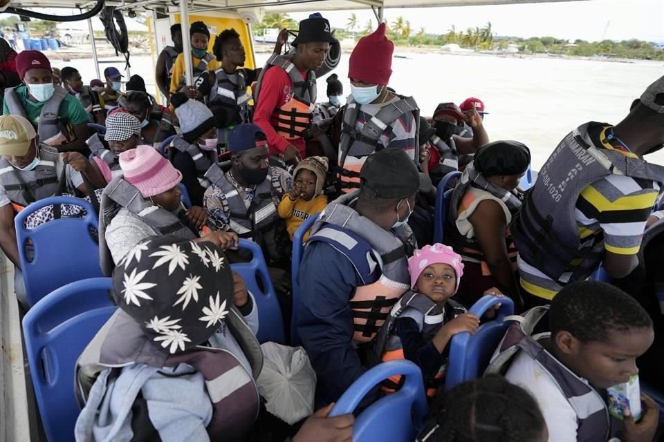 Migrantes haitianos se sientan en un bote en Necoclí, en la costa Caribe de Colombia, para zarpar con rumbo al poblado de Acandí, cerca de la frontera con Panamá, este lunes.