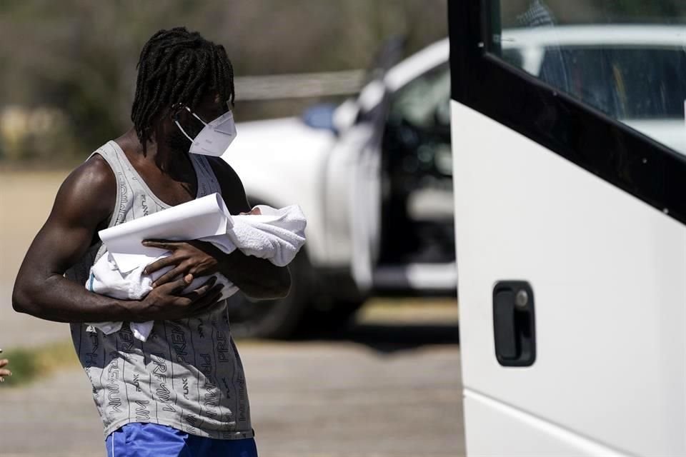 Un migrante en Houston sostiene un bebé luego de ser liberado en Estados Unidos.