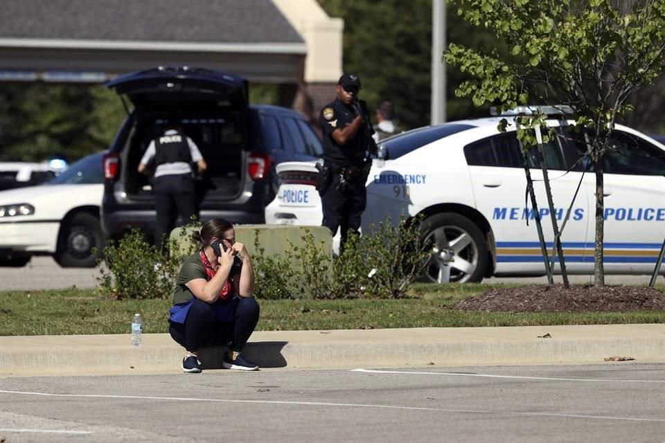 Una mujer hace una llamada en el estacionamiento de la tienda después de salir de las instalaciones por el tiroteo.