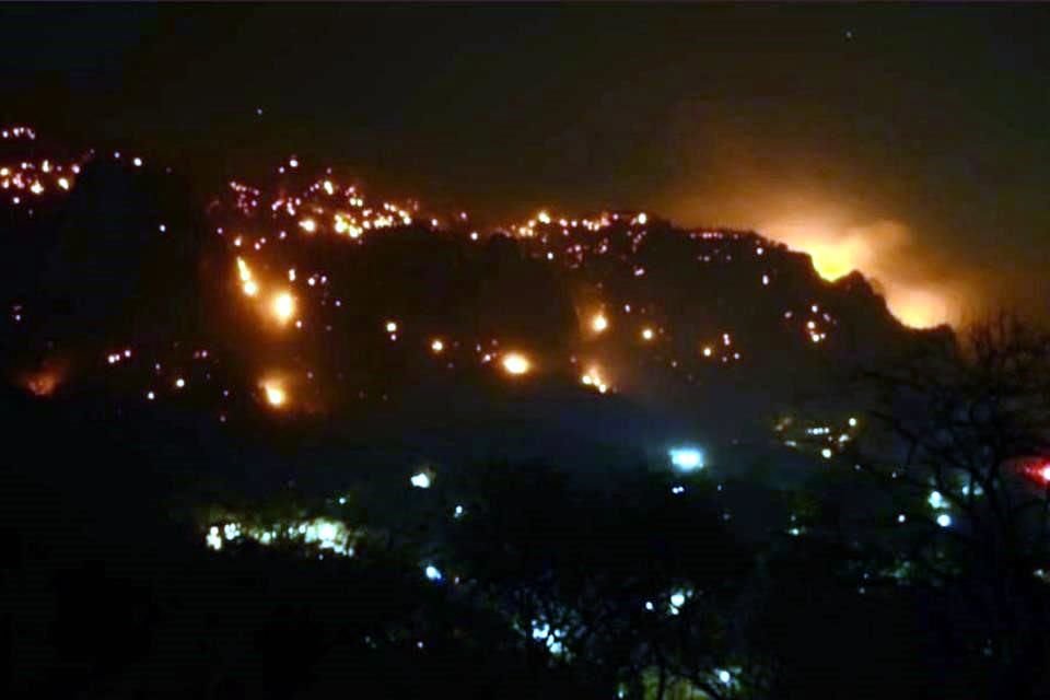 A causa del viento, incendio en Tepoztlán, Morelos, se reavivó y se acercó a viviendas, por lo que habitantes piden ayuda para desalojar.