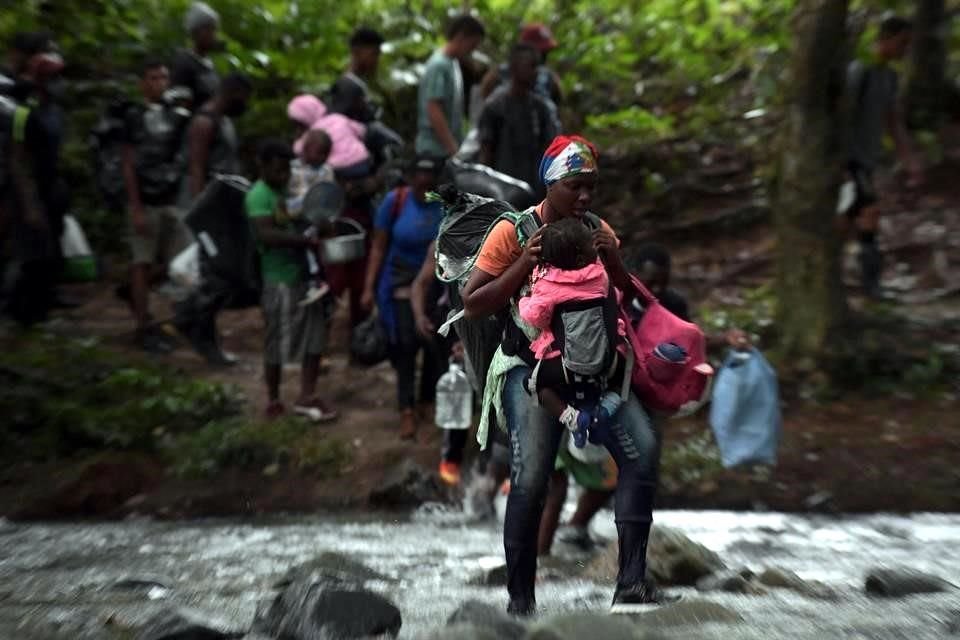 Migrantes haitianos, muchos con niños, cruzan la selva del Darién a pie.