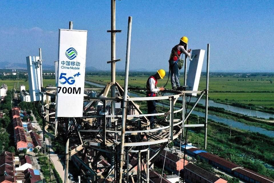 Trabajadores instalan y ponen en marcha antenas de estación base 5G en una torre de estación base de comunicaciones en la ciudad de Laozhou, un suburbio de la ciudad de Tongling, provincia de Anhui.