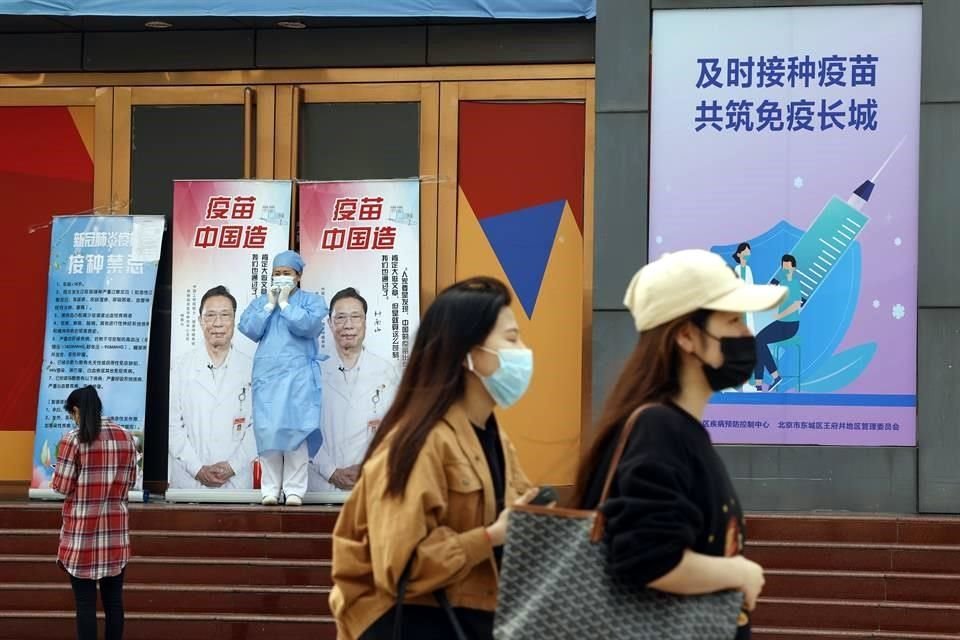 Un trabajador médico junto a publicidad que muestran al renombrado Dr. Zhong Nanshan con las palabras 'Vacuna hecha en China' en un centro de vacunación en Beijing.