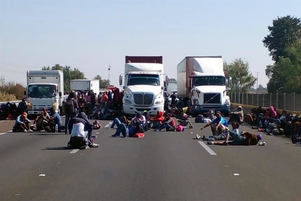 Migrantes bloquean la México-Puebla en protesta por operativo de GN que les impide subir a vehículos.