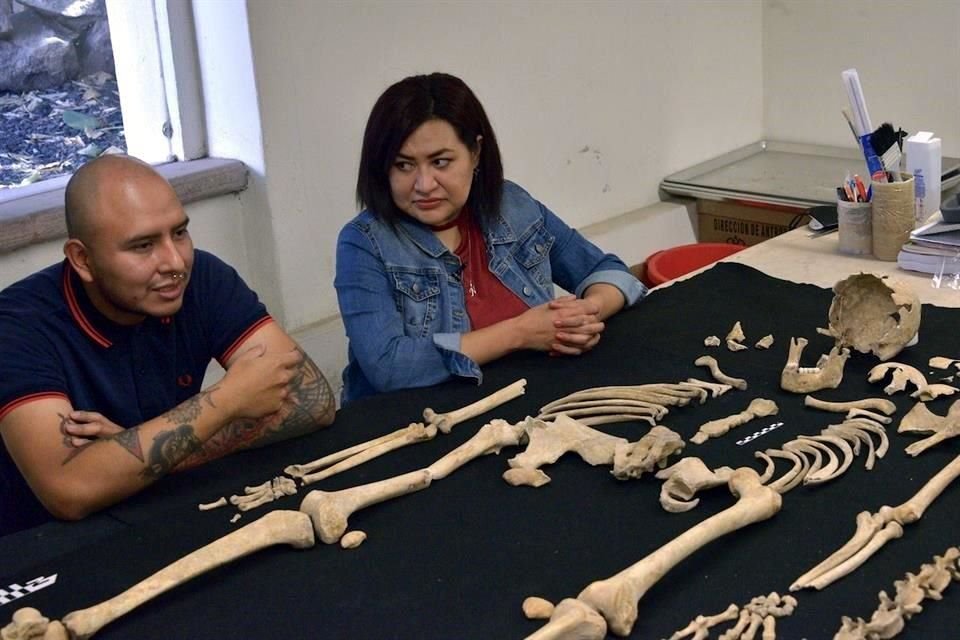 El antropólogo físico Eduardo García y la arqueóloga Nancy Domínguez muestran la osamenta de un joven de unos 25 años de edad y 1.80 metros de estatura, hallado junto con otros 16 enterramientos.