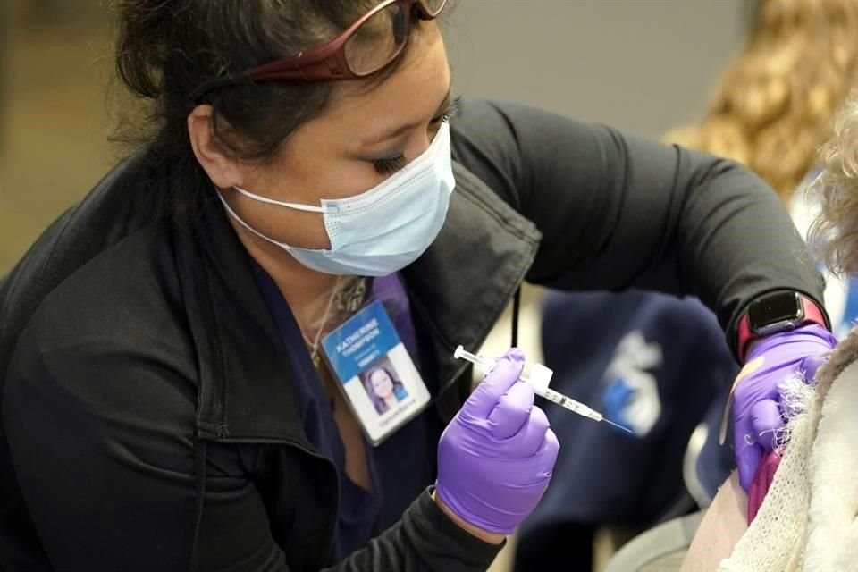 Personal médica administra una vacuna de refuerzo de Pfizer en Washington.