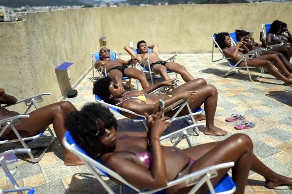 Personas toman el sol en el salón de azotea 'Sabrina Bronze' en la favela Turano de Río de Janeiro, Brasil.
