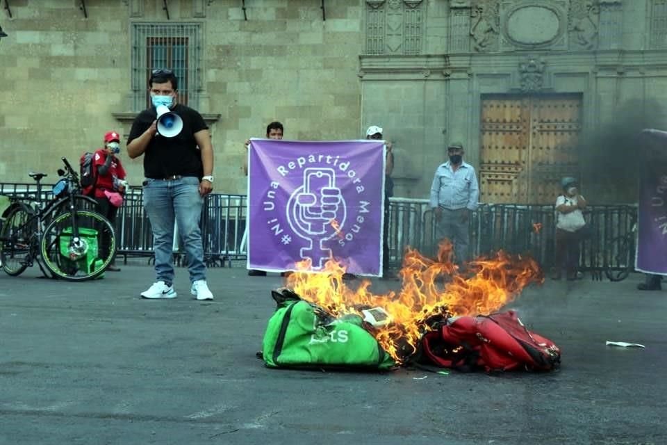 Repartidores por aplicación se manifestaron al quemar sus mochilas frente a Palacio Nacional para exigir mejores condiciones laborales.