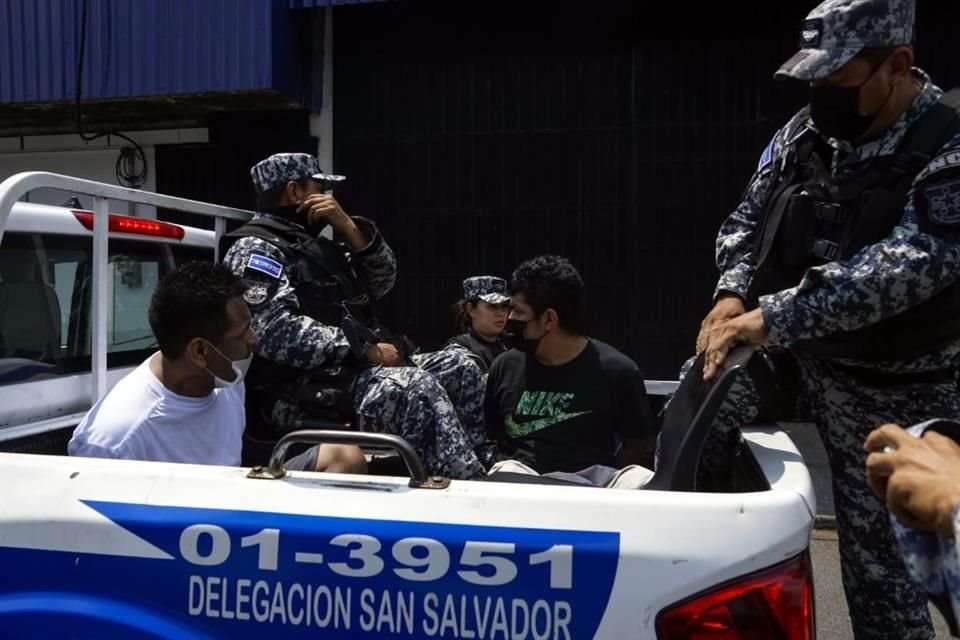 Agentes de la Policía Nacional Civil salvadoreña trasladan a personas detenidas durante un operativo de seguridad, en el departamento de San Salvador.