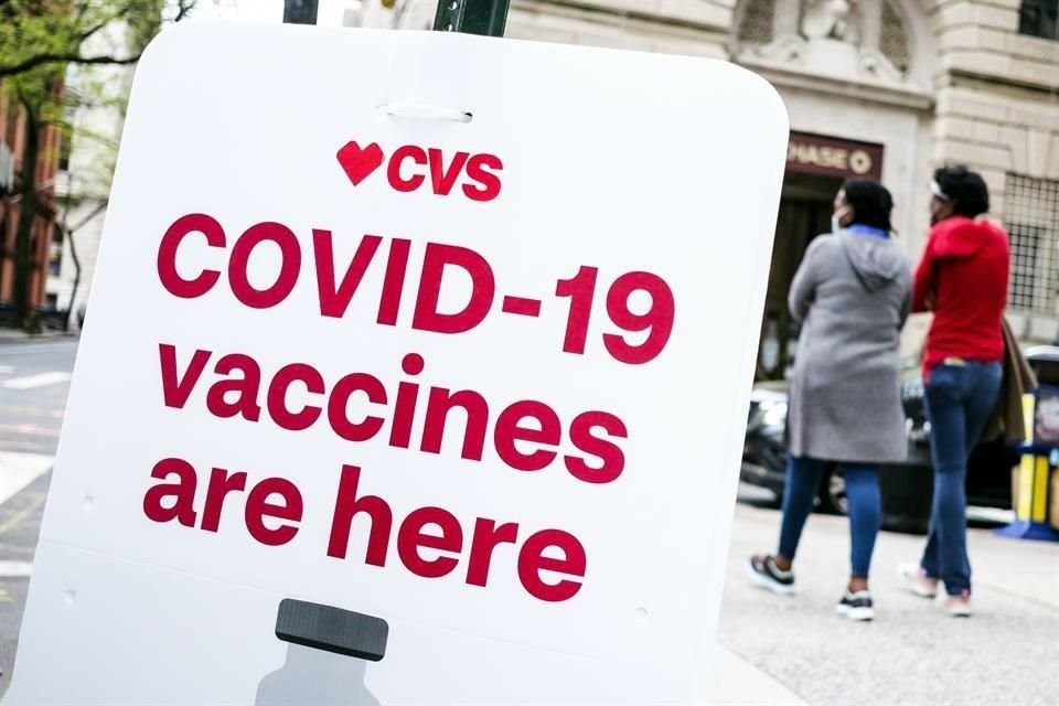 Dos personas caminan por una farmacia en Nueva York donde se aplican las vacunas contra Covid.