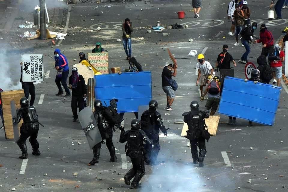 Manifestantes se enfrentan con miembros del Escuadrón Móvil Antidisturbios (ESMAD) durante las protestas, el lunes, en Cali, Colombia.
