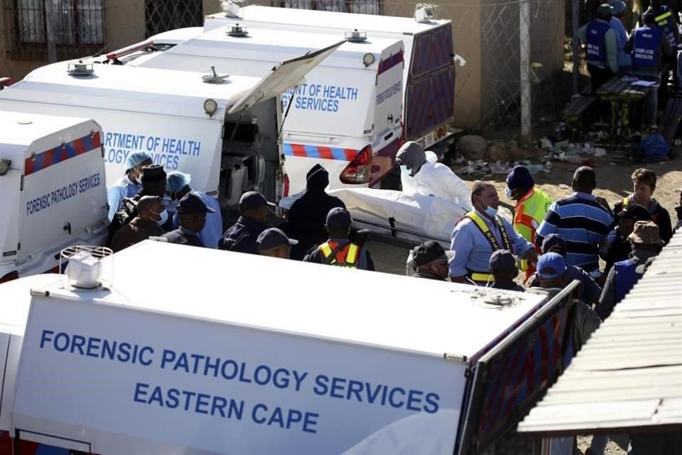 Servicios de emergencia en East London, Sudáfrica retiran los cuerpos hallados en un bar informal.