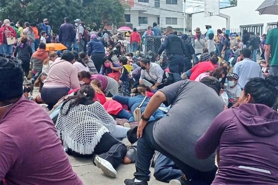 Padres de familia se resguardan al escuchar disparos en la fila de vacunación en Puebla.