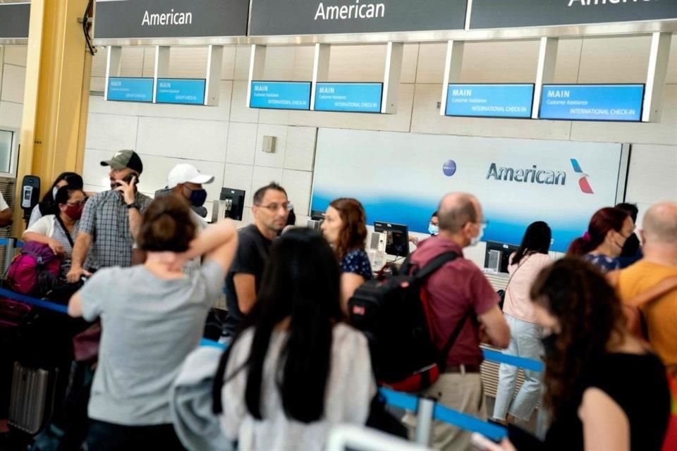viajeros esperan en fila en un mostrador de American Airlines en el Aeropuerto Nacional Ronald Reagan de Washington.