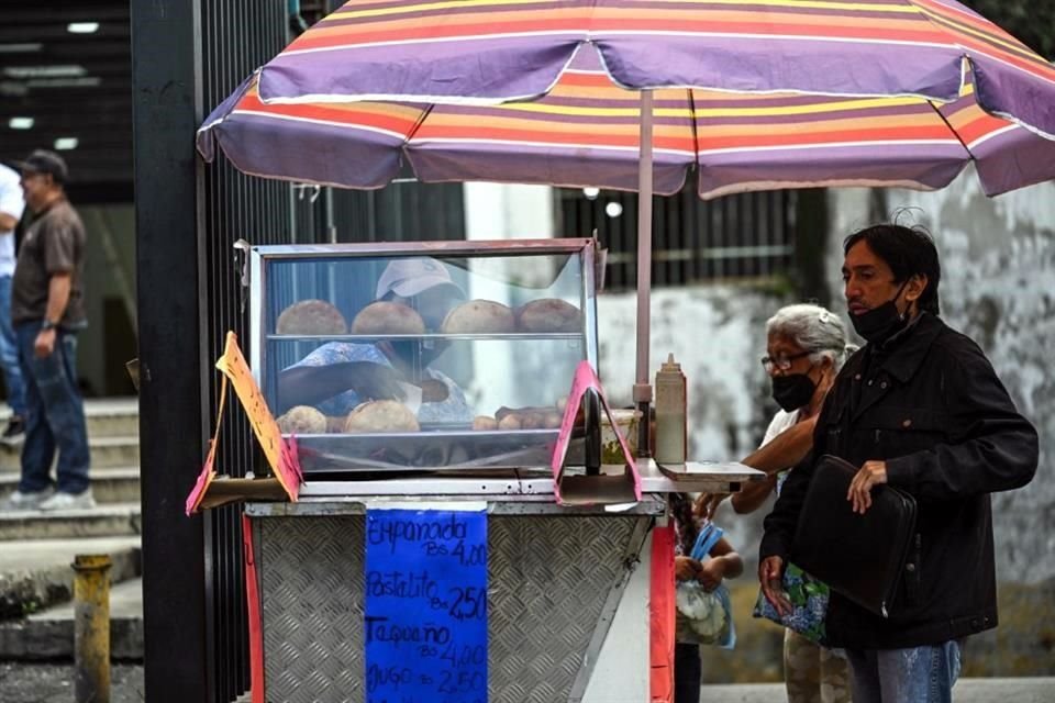 Personas en Caracas, Venezuela, compran comida en un puesto callejero.
